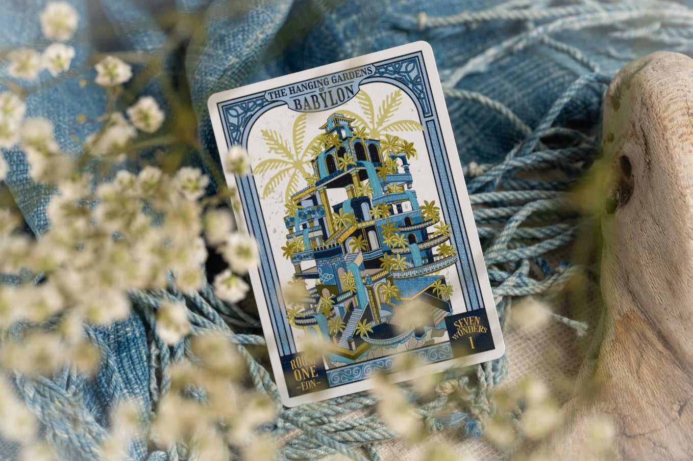 55th face card with 'Babylon' design on a textured surface with flowers.