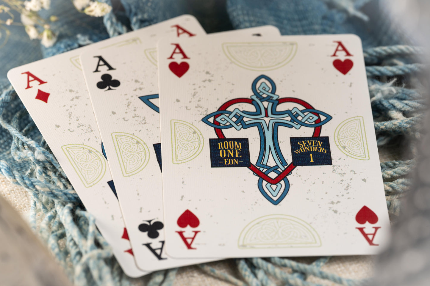 Three Ace cards with a unique design on a textured surface