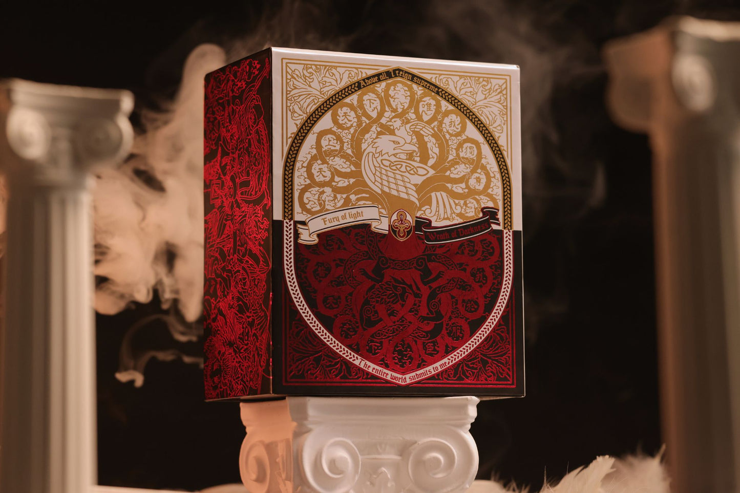 Mythic Divide Playing Cards Collector's box with intricate design on a stand, surrounded by smoke.
