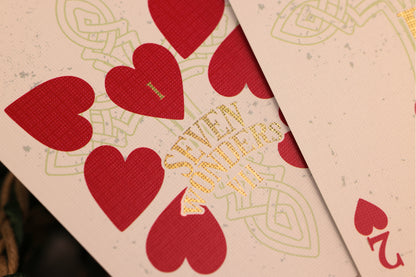 Close-up of playing cards with red hearts and gold foil detailing.
