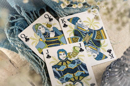 Three Court cards featuring queens, kings, and jacks on a textured surface with floral elements.