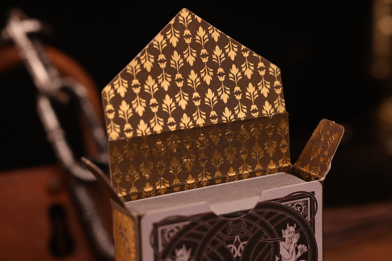 Diamonds Edition decorative tuck box interior with intricate gold patterns on a dark background