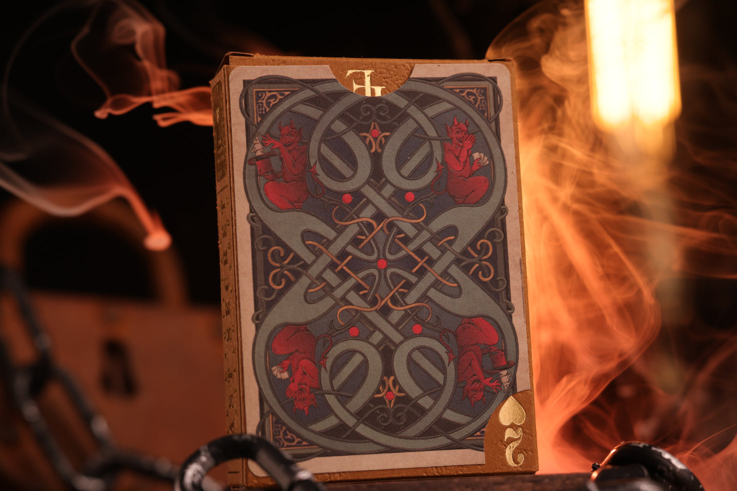 Hearts Edition tuck box with intricate designs on fire and chains in the background