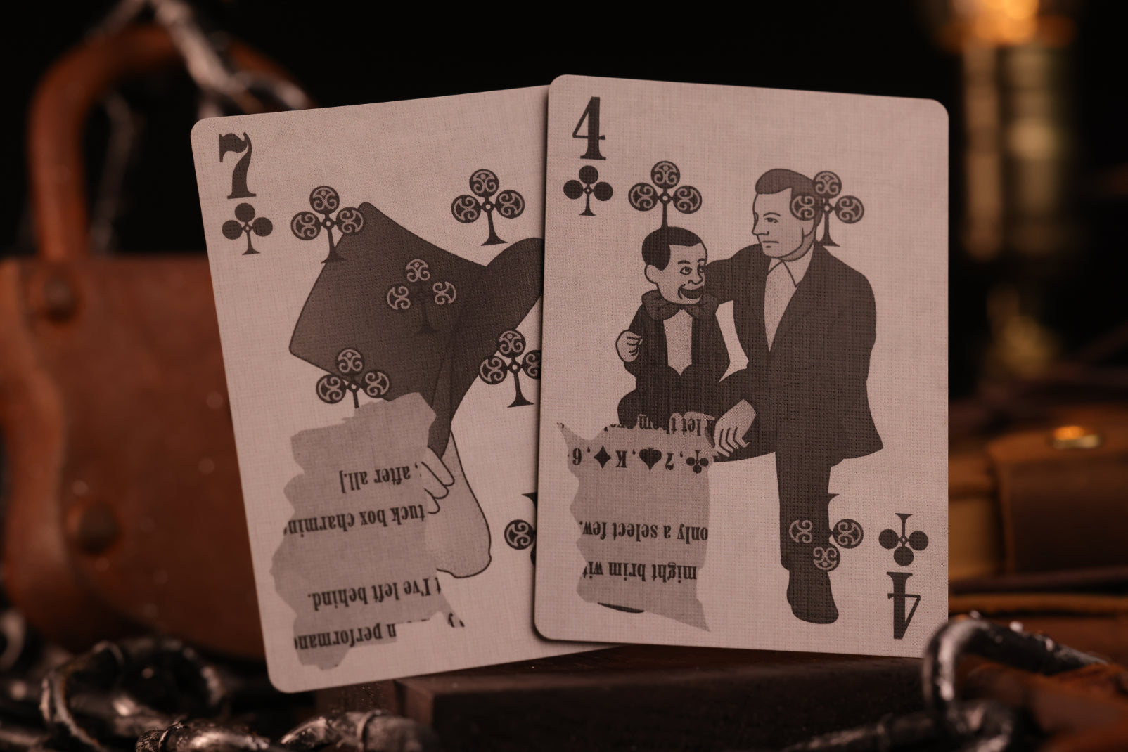 Two number cards with black illustrations of top hat and ventriloquist.