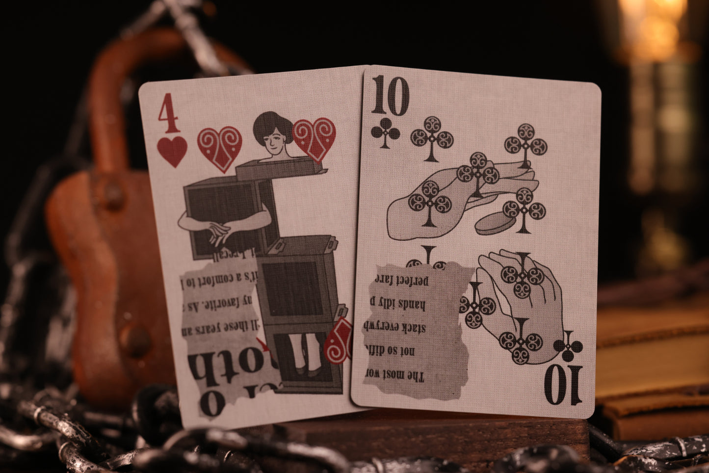 Two number cards, the 4 of hearts and the 10 of clubs, on a dark background with a blurred object in the background.