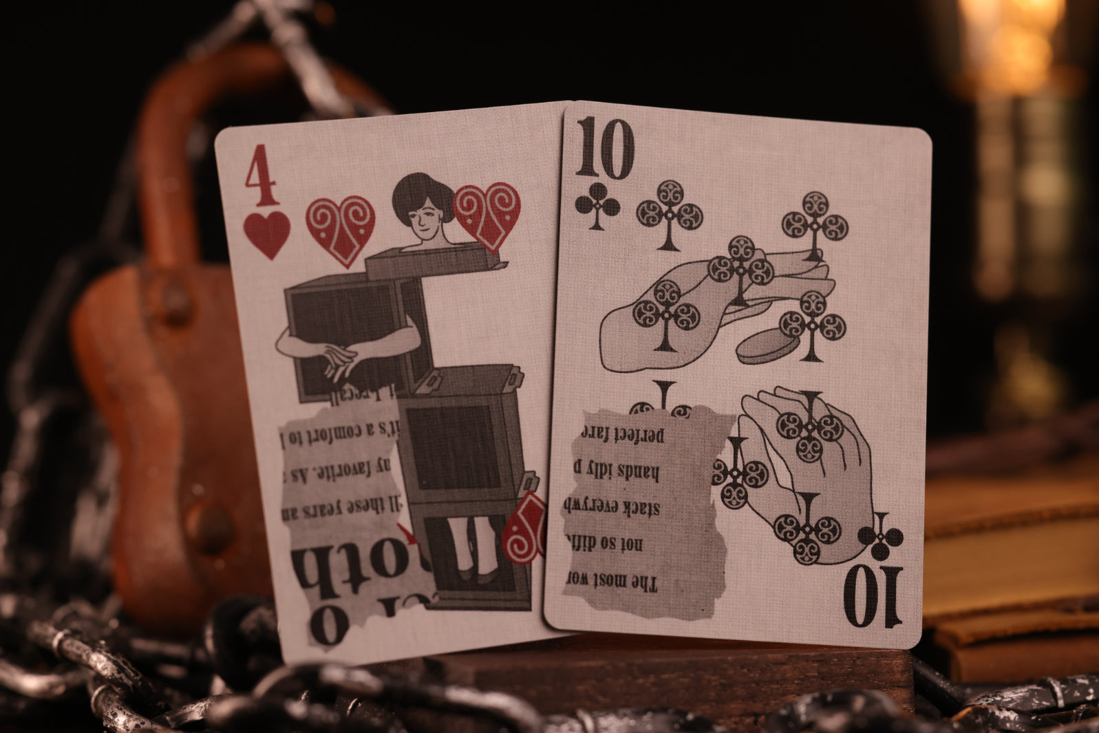 Two number cards, the 4 of hearts and the 10 of clubs, on a dark background with a blurred object in the background.