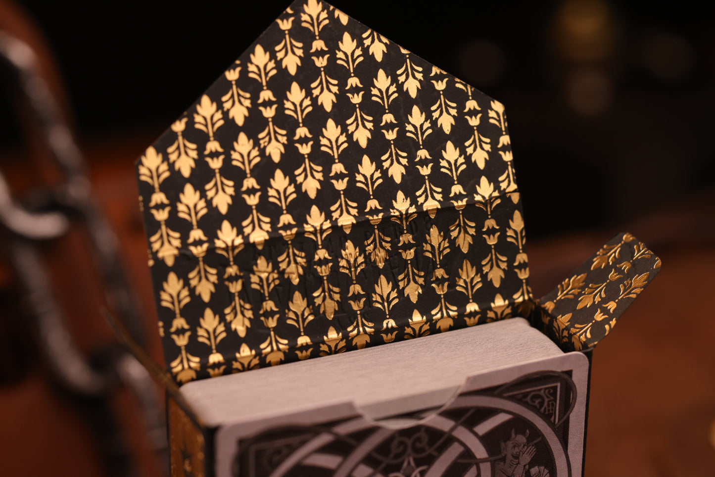 Clubs edition tuck box interior featuring a hot foil gold floral pattern on a dark background