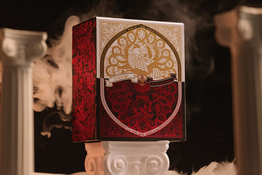 Mythic Divide Playing Cards Collector's box with intricate design on a stand, surrounded by smoke.