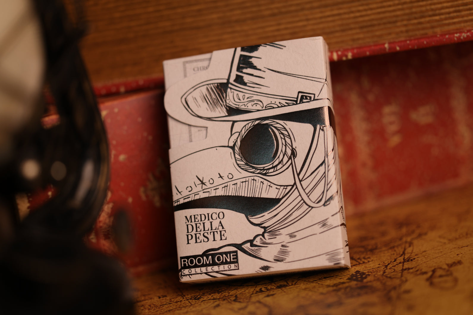 A deck of Veil Edition Plague Doctor Playing Cards on a wooden surface