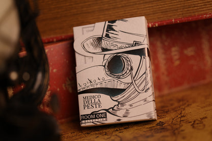 A deck of Veil Edition Plague Doctor Playing Cards on a wooden surface