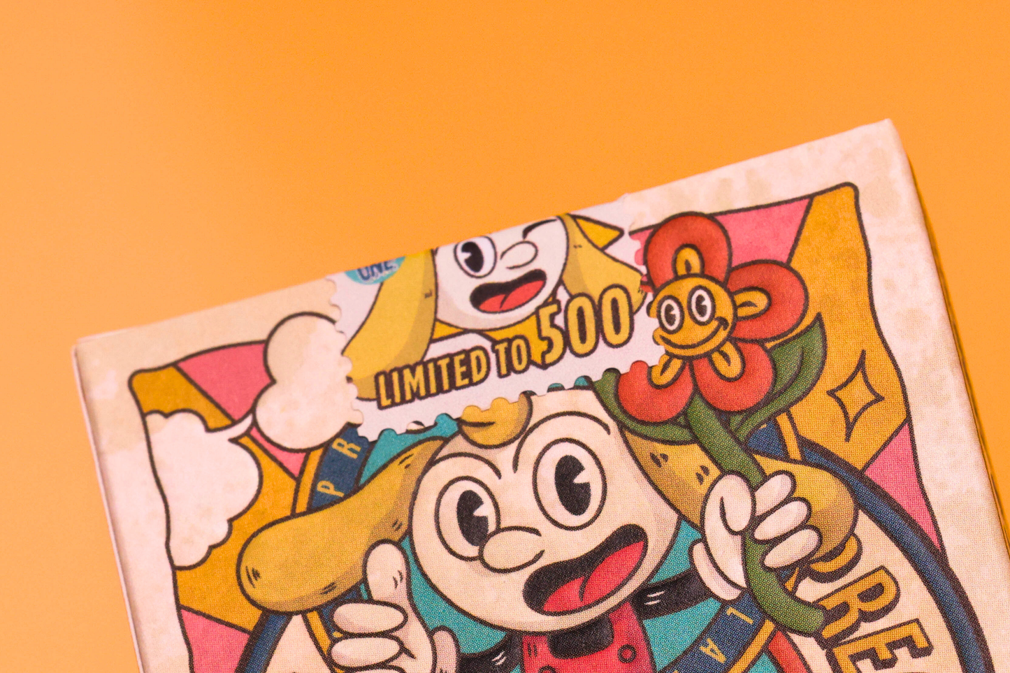 Prequel Gilded Editon tuck box with cartoon illustrations on a bright orange background