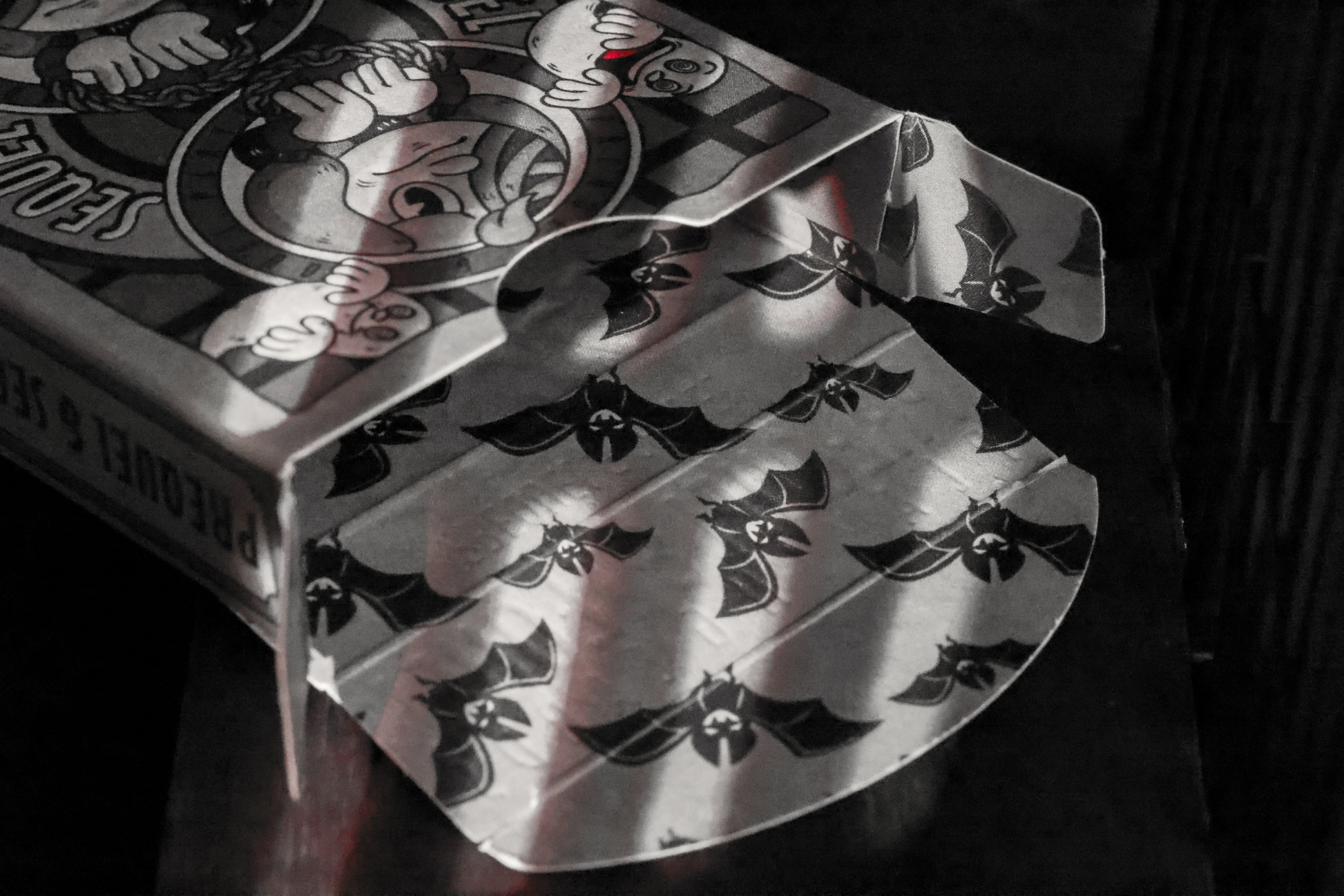 Close-up of the Sequel Edition tuck box interior, featuring intricate designs on a dark background