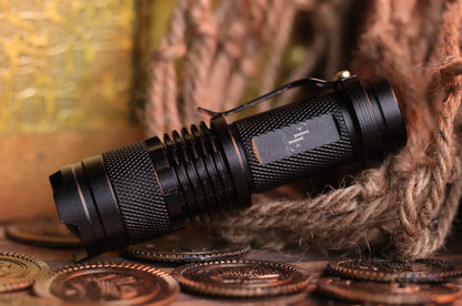 A black UV flash light with a textured grip is placed on a surface with coin-like items around it, possibly indicating a gaming or puzzle-solving context.
